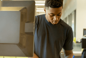 Young man writing on desk paper