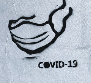 Black spray paint of Covid-19 on a white wall