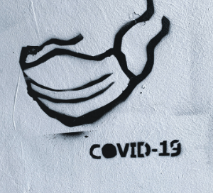 Spray paint of a covid-19 sign on a white wall