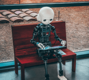 Robot sitting on a bench looking at a book
